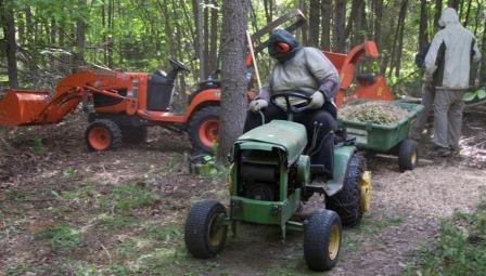 Gloria on the tractor, Mike at the wood chipper. Photo by Richard Longley.
